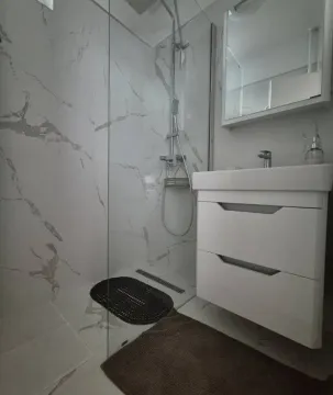 Modern bathroom with a walk-in shower and a white vanity unit. - image 3