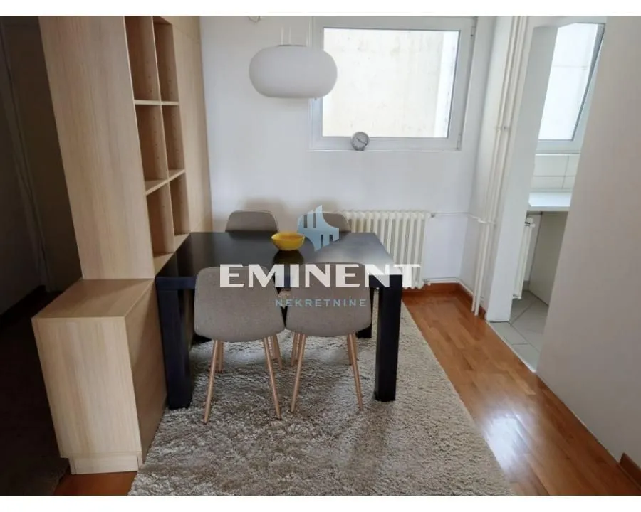 Dining area with a table, chairs, and a wooden partition shelf.