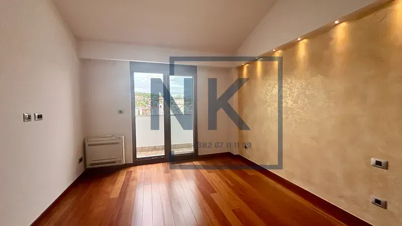 Empty living room with hardwood flooring and balcony access.