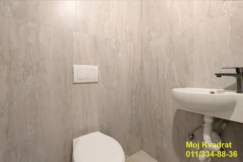 Manje kupatilo obloženo keramičkim pločicama sa umivaonikom i šoljom. - image 12