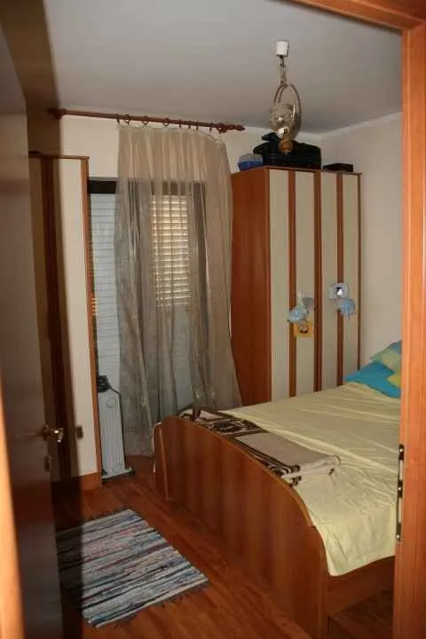 Jednostavna spavaća soba sa drvenim namještajem.