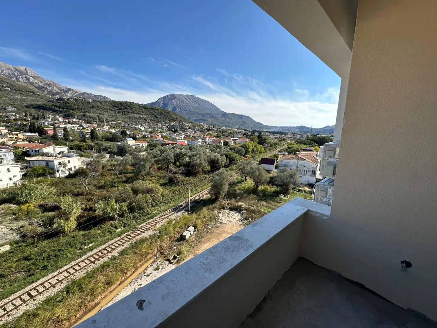 View from the balcony overlooking the surrounding settlement, hills, and railway.