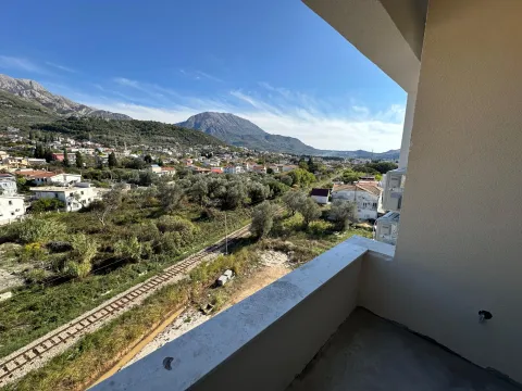 View from the balcony overlooking the surrounding settlement, hills, and railway. - image 2