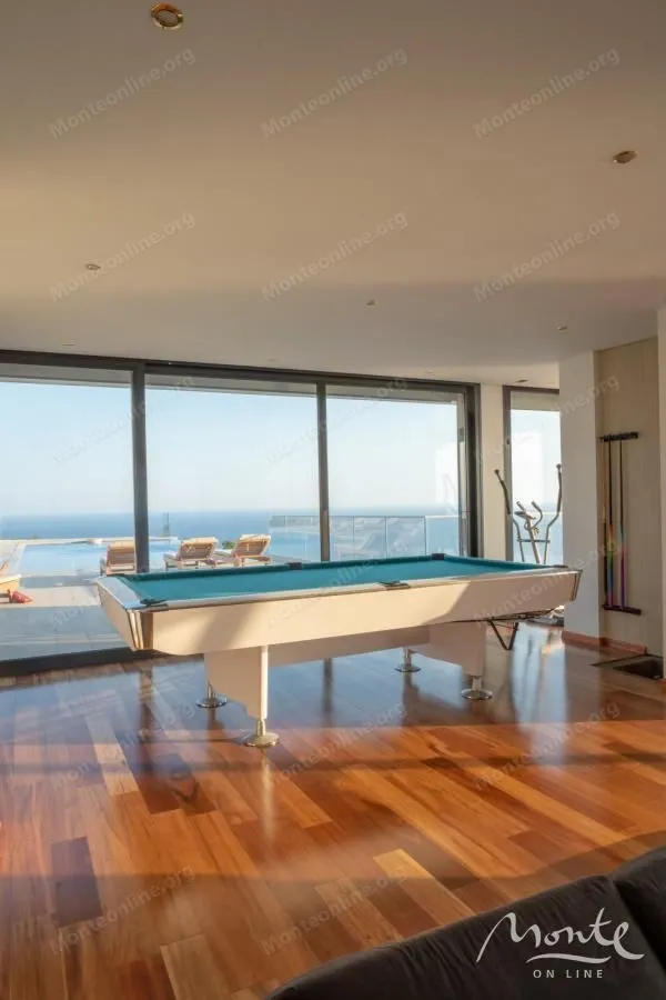 Spacious living room with a pool table and sea view.