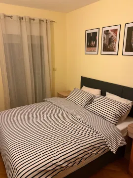 Namještena spavaća soba sa bračnim krevetom, zavjesama i slikama na zidu. - image 12