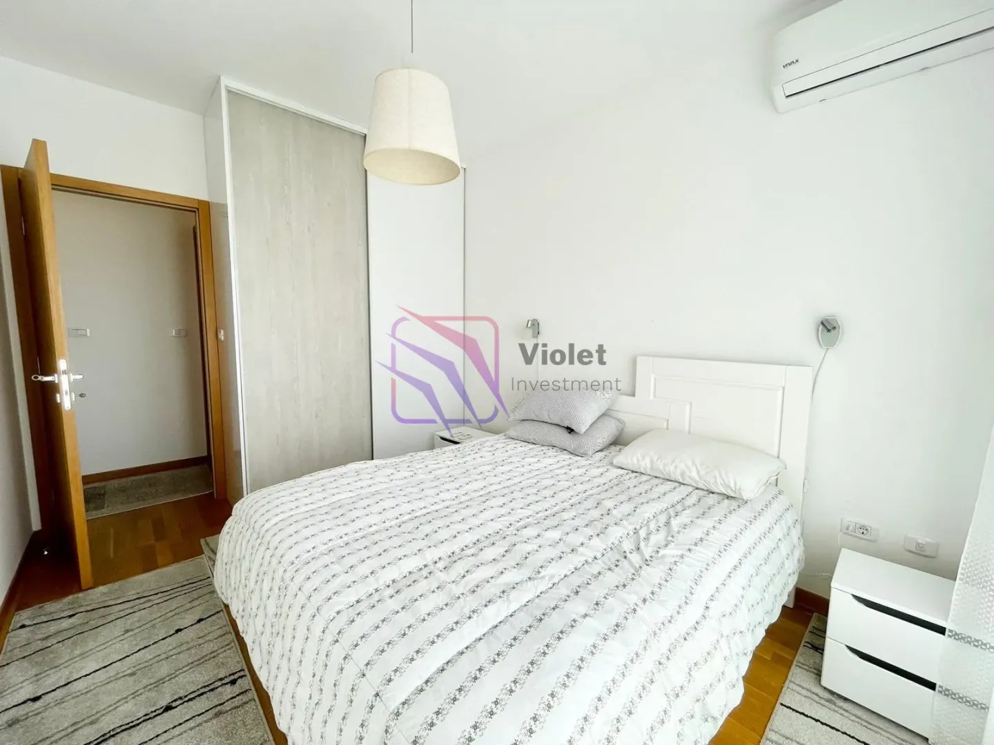 Furnished bedroom with a double bed, wardrobe, and air conditioning.