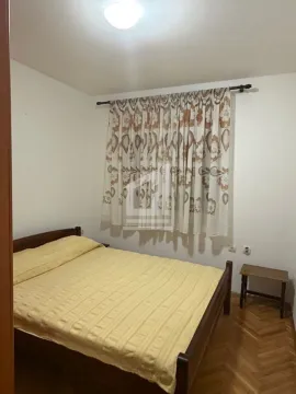 Bedroom with a double bed and a window with curtains. - image 3