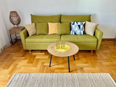 Living room with a green sofa and a wooden coffee table. - image 4