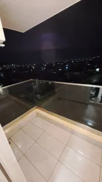 Popločani balkon sa staklenom ogradom i pogledom na grad noću. - image 8
