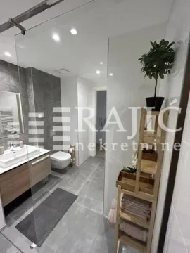 Modern bathroom with a walk-in shower, washbasin, and toilet. - image 3