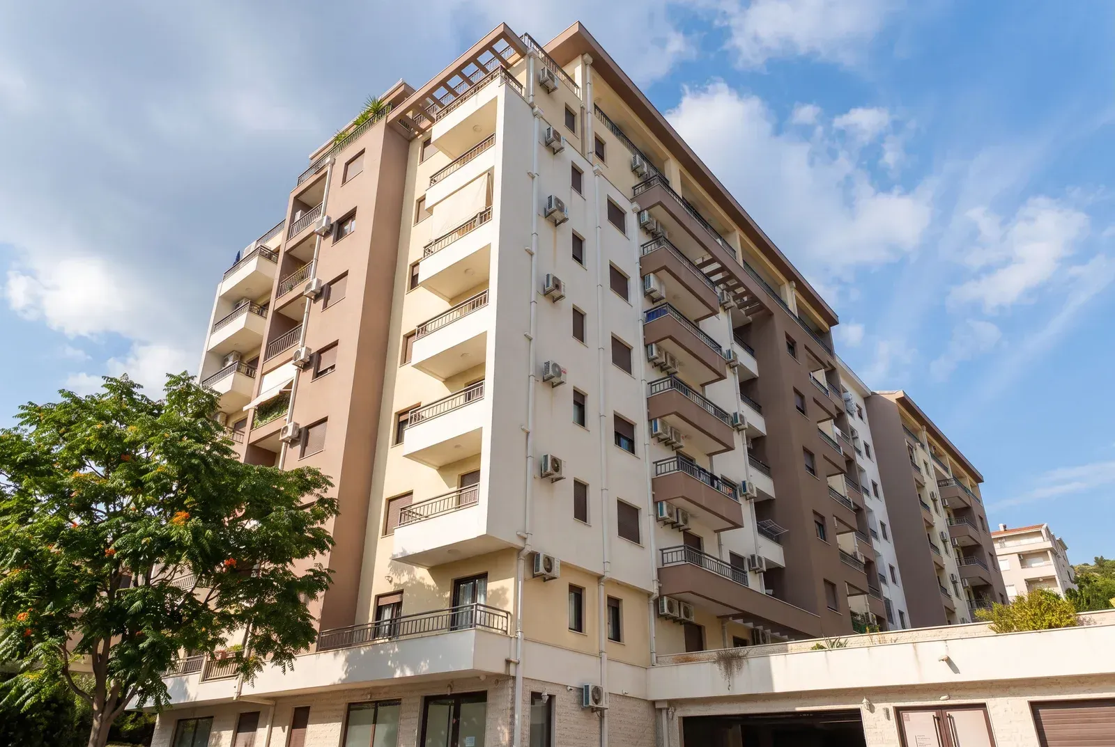 Spoljašnji izgled višestambene stambene zgrade sa terasama i fasadom.