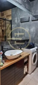 Modern bathroom with a washbasin on a wooden counter and a washing machine. - image 6