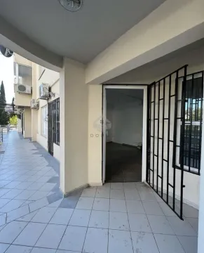 Entrance to commercial space with a tiled walkway and security bars on the windows. - image 8