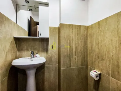 Manje kupatilo sa umivaonikom, ogledalom i bež pločicama. - image 18
