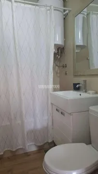 Smaller bathroom with a washbasin, toilet, shower and water heater. - image 13