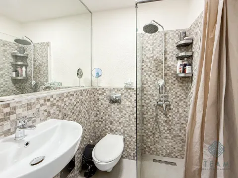 Compact bathroom with a shower cabin, washbasin, and toilet. - image 7