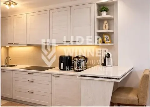 Kitchen in light tones with wood-textured cabinetry and a dining bar. - image 8