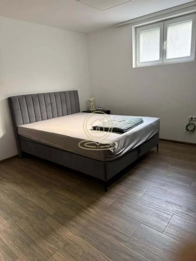 Spavaća soba sa velikim bračnim krevetom i prozorom.