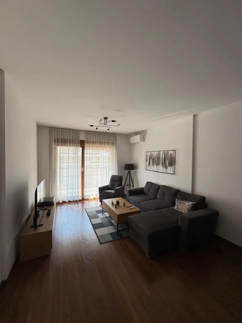 Living room with a sofa, coffee table and TV.