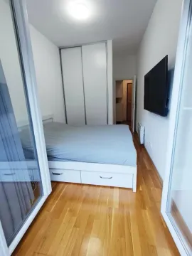 Smaller bedroom with a double bed, wardrobe, and wall-mounted television. - image 7