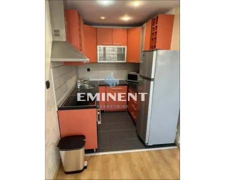 Small kitchen with orange cabinets and a refrigerator. - image 5