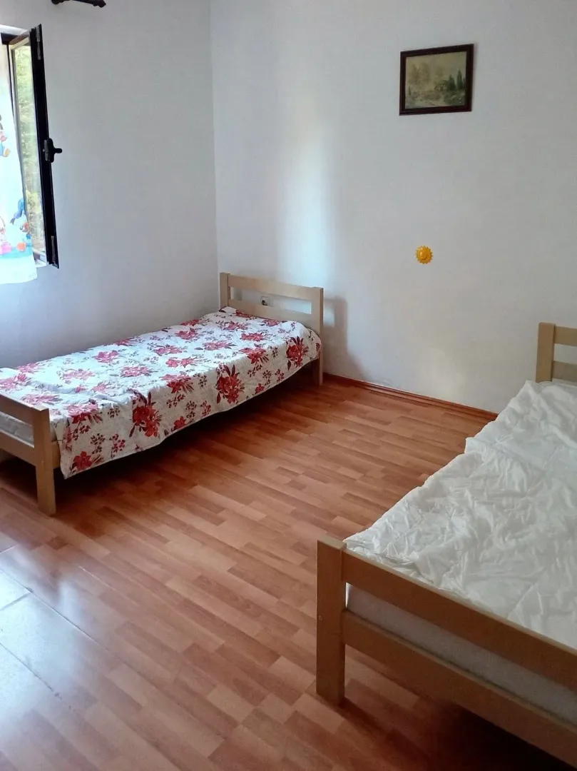 Bedroom with two wooden beds and laminate flooring.