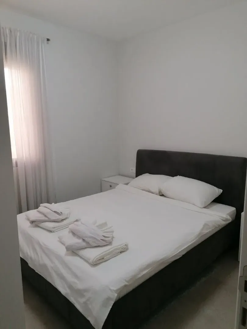 Svijetla spavaća soba sa bračnim krevetom.