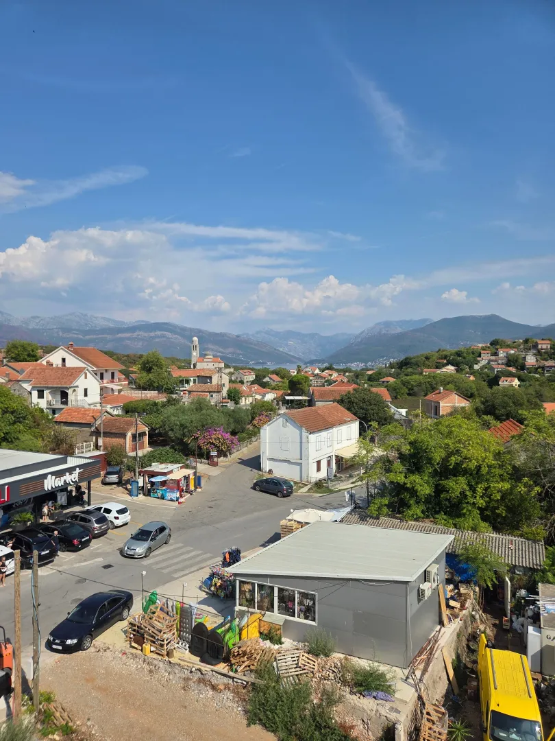 Pogled sa terase na naselje, okolne ulice i planine u daljini.