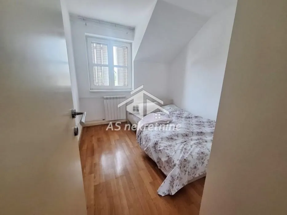 Smaller bedroom with a bed and a window.