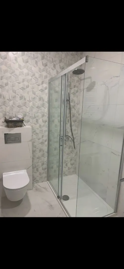 Moderne kupatilo sa tuš kabinom i ugradnim wc šoljom.
