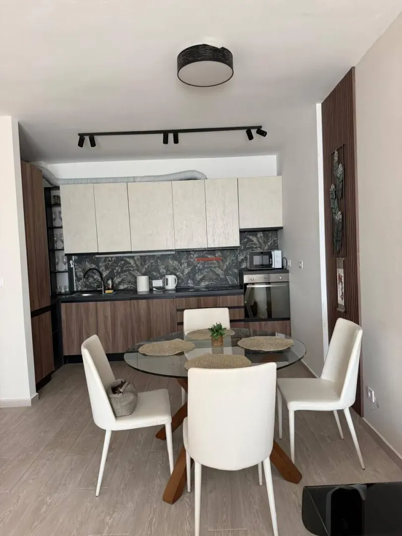 Modern kitchen with a dining table and white chairs.