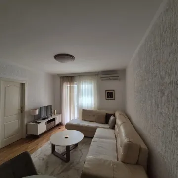 Bright living room with a corner sofa, coffee table, and TV unit. - image 2