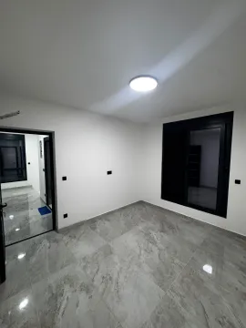 Empty room with gray tiles and black window frames. - image 12
