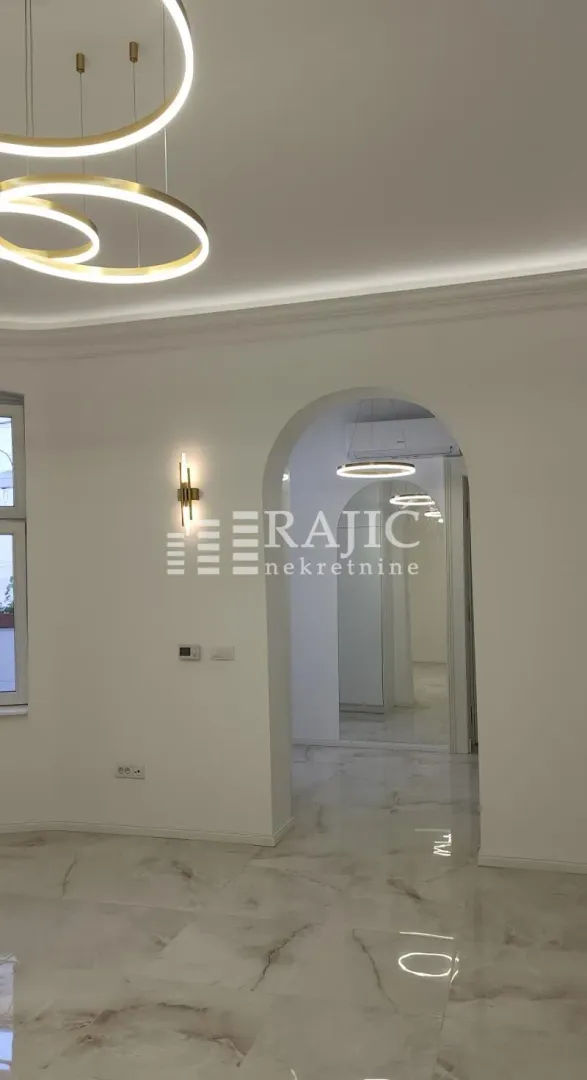 Bright living room with modern chandeliers and luxury marble flooring.
