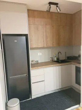 Smaller modern kitchen with built-in cabinetry and refrigerator. - image 10