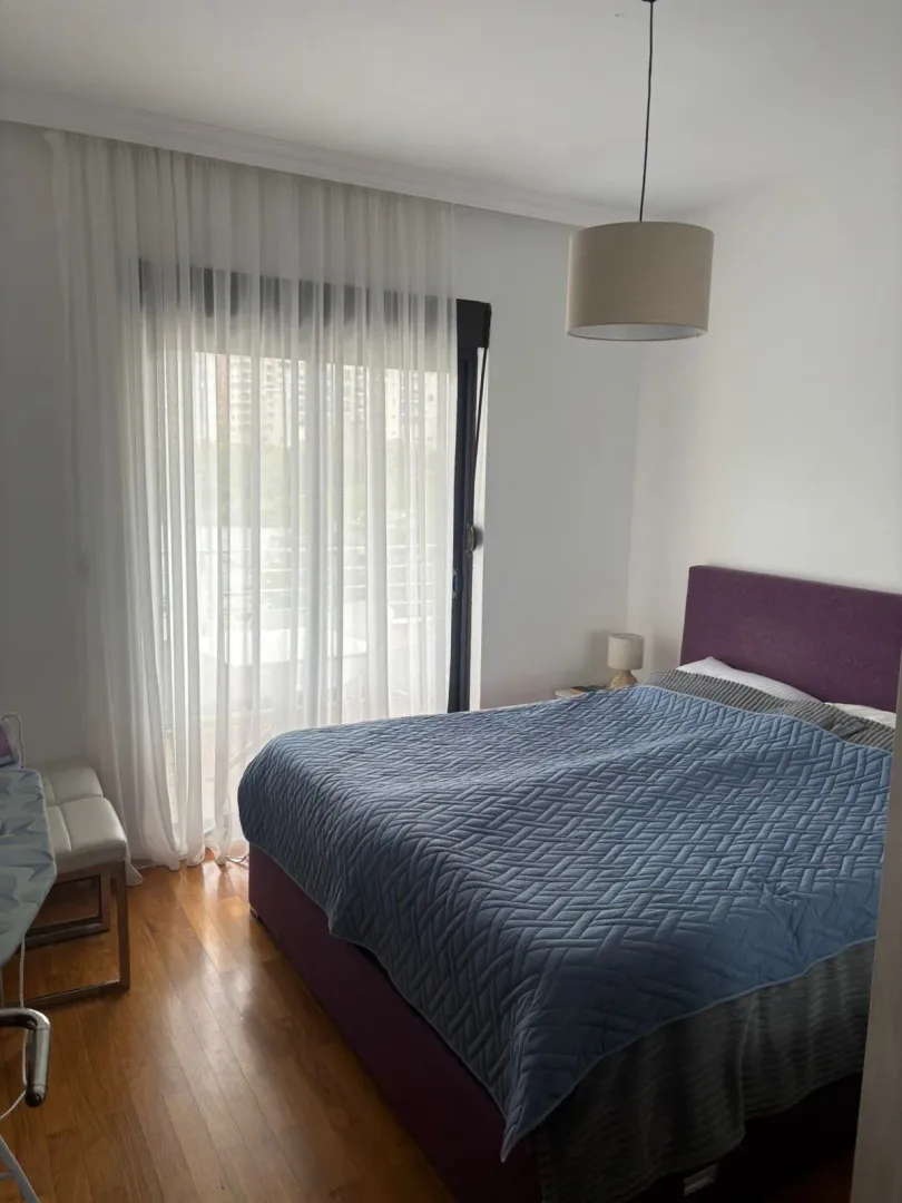 Furnished bedroom with a double bed and balcony access.