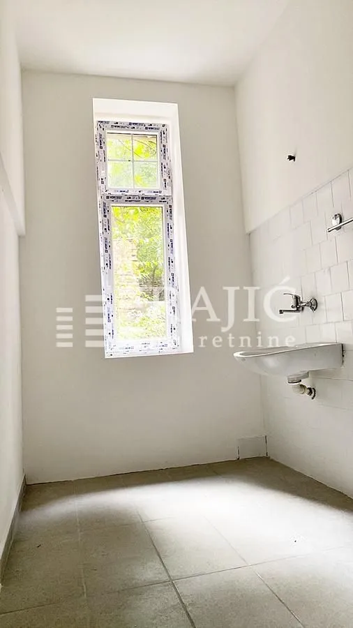 Empty bathroom with a sink and a window.