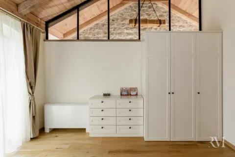 Bright bedroom area with wooden flooring, a white wardrobe, and a chest of drawers. - image 13
