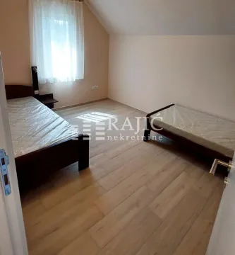 Attic bedroom with two beds and laminate flooring. - image 8