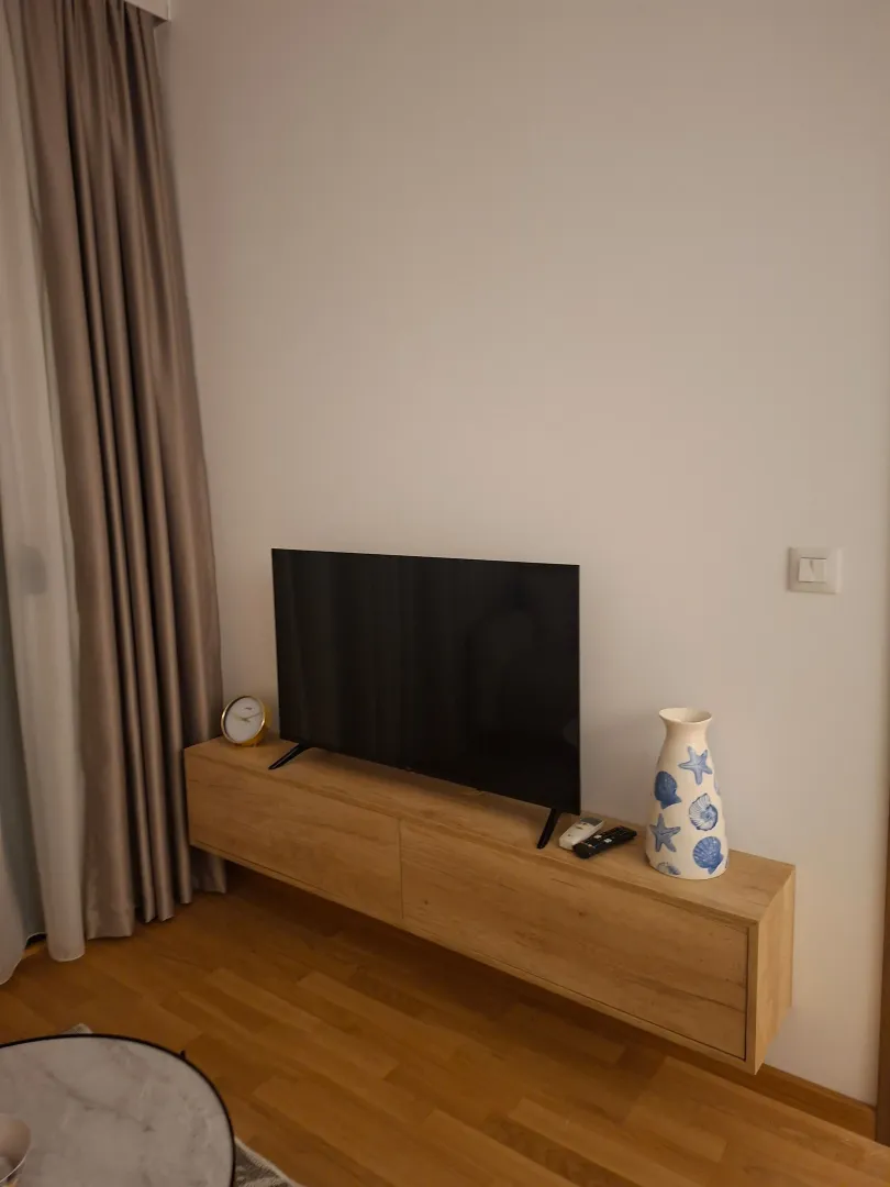 Living room with a TV on a console unit and decorative details.