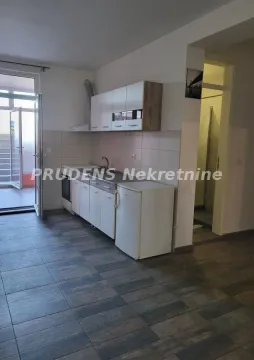 Smaller kitchen with white cabinetry and access to the terrace. - image 3