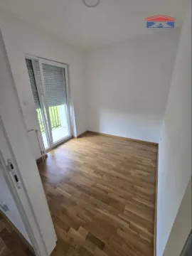 Prazna soba sa drvenim podom i balkonskim vratima. - image 7