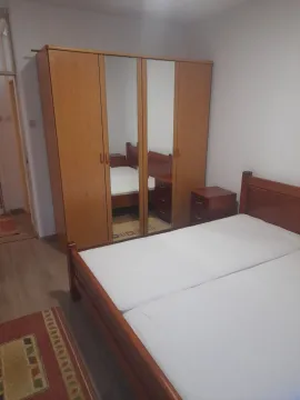 Spavaća soba sa drvenim krevetom i velikim trokrilnim ormarom sa ogledalima. - image 4