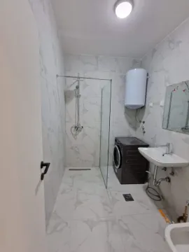 Savremeno opremljeno kupatilo sa tuš kabinom, umivaonikom i veš mašinom. - image 12
