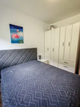 Bedroom with a double bed, wardrobe, and a flamingo painting on the wall. - image 13