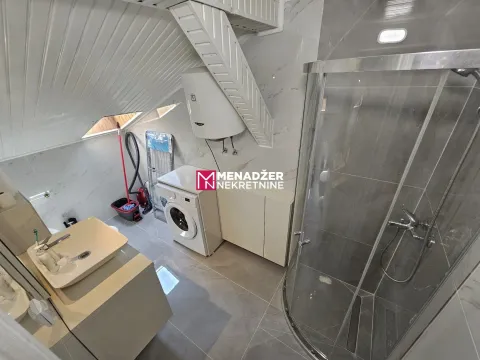 Kupatilo sa tuš kabinom, umivaonikom i mašinom za pranje veša pod kosim krovom. - image 6
