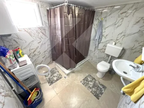 Bathroom with a shower cabin, toilet, washbasin, and washing machine. - image 7