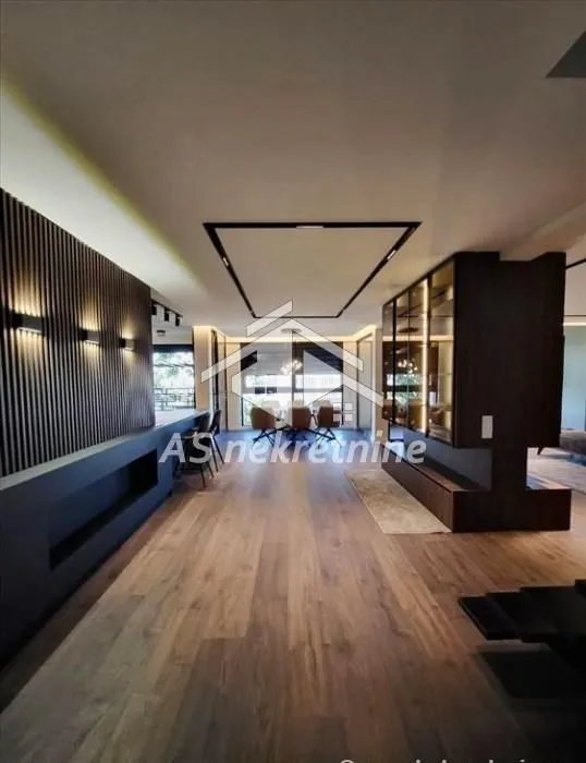 Spacious living room with modern wood wall paneling and hardwood flooring.