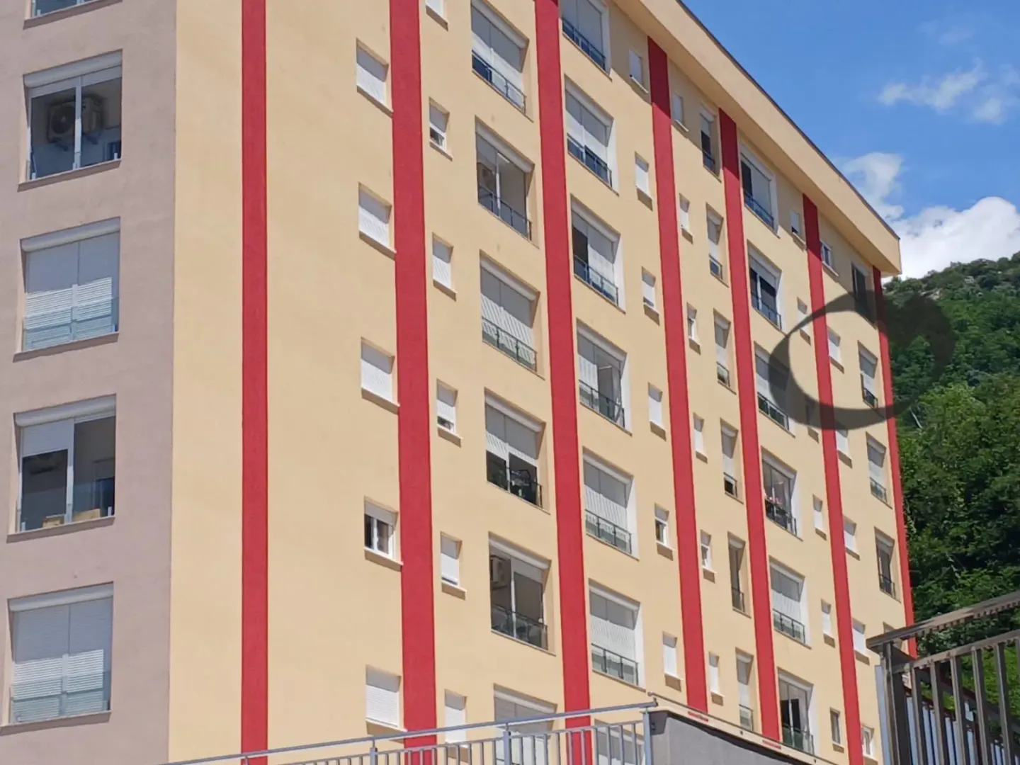 Spoljašnji izgled višestambene zgrade sa šarenom fasadom.