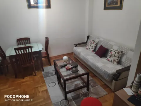 Living room with a sofa, coffee table, and a small dining set. - image 2